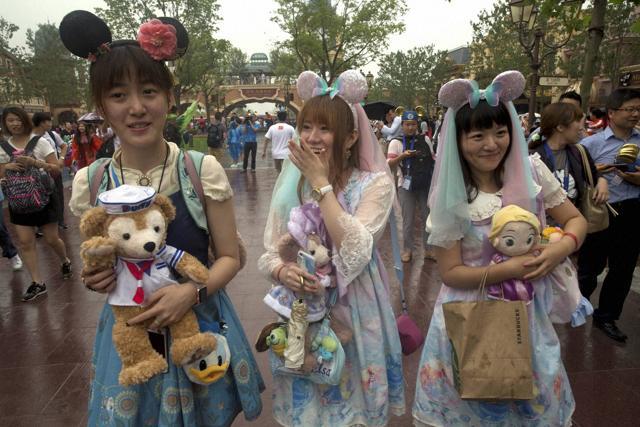Visitors dress up as they attend the opening day of the Disney Resort. (AP)