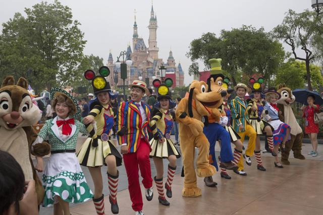 Performers take part in a parade with various Disney characters on the opening day. (AP)