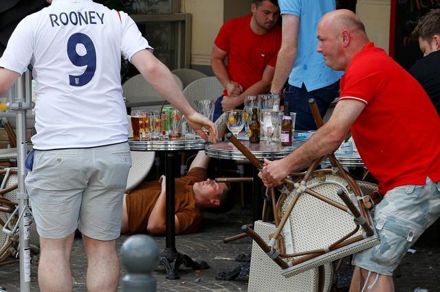 England and Wales fans react after some scuffles with Russian supporters outside a pub in Lille, France. (Reuters Photo) England and Wales fans react after some scuffles with Russian supporters outside a pub in Lille, France. (Reuters Photo)