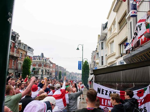 A flare is ignited as England fans hang a flag onto a bar's canopy in central Lens, on the day that England play Wales during the Euro 2016 football tournament. (AFP) A flare is ignited as England fans hang a flag onto a bar's canopy in central Lens, on the day that England play Wales during the Euro 2016 football tournament. (AFP)