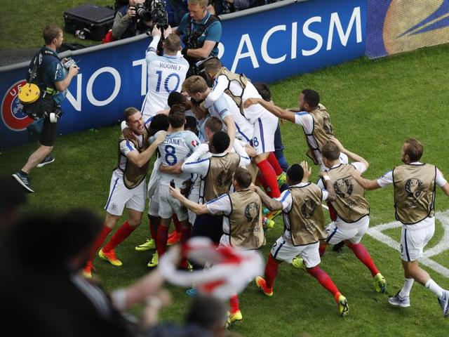England players rush to the sideline to celebrate the winning goal. (AP)