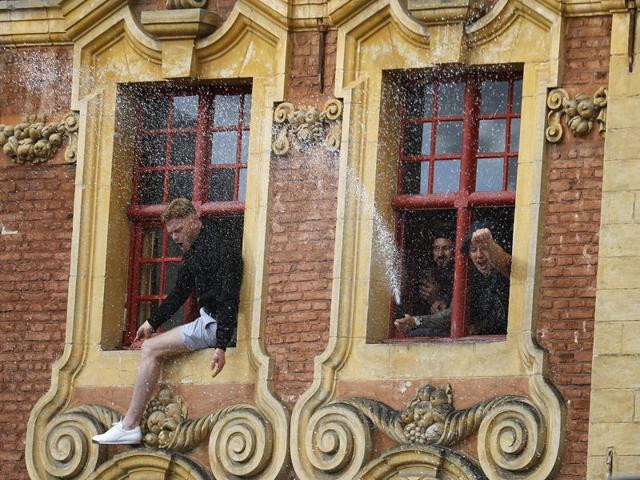 England spray alcohol out of a hotel window in downtown Lille, France, one day ahead of the Euro 2016 Group B match against Wales in nearby Lens.  (AP Photo) 