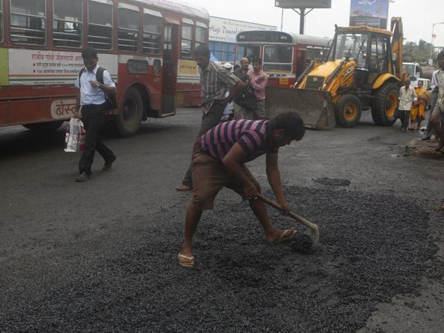 BMC workers filling potholes opposite Mahim church in Mumbai. (Photo by Satish Bate/ Hindustan Times) (Hindustan Times) BMC workers filling potholes opposite Mahim church in Mumbai. (Photo by Satish Bate/ Hindustan Times) (Hindustan Times)