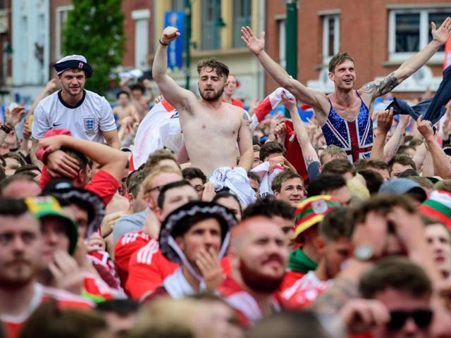 Celebrating England fans look on at dejected Welsh fans (foreground) in the fanzone in central Lens as England beat Wales 2-1. (AFP photo) Celebrating England fans look on at dejected Welsh fans (foreground) in the fanzone in central Lens as England beat Wales 2-1. (AFP photo)