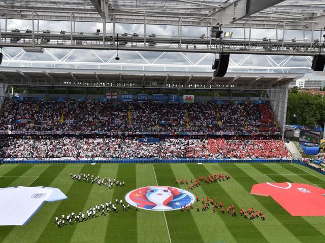 Volunteers perform with a flag showing the logo of the Uefa Euro 2016 football tournament prior to the start of the match. (AFP)
