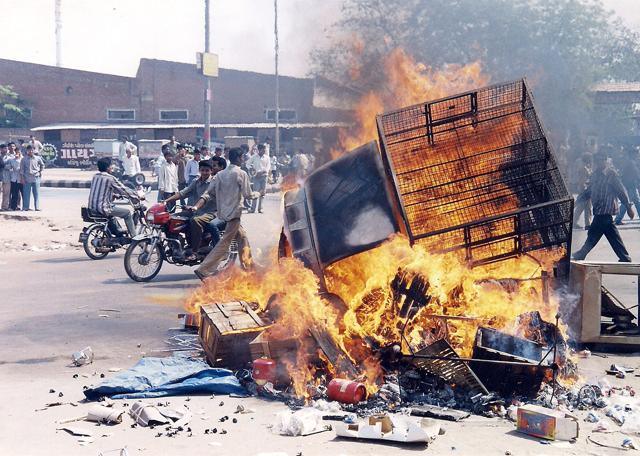 File photo of a biker passing near a burning vehicle during 2002 Gujarat riots. (PTI)