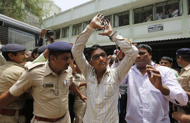 A man convicted for the 2002 Gujarat riots is taken back to jail after the court announced the lengths of the sentences in Ahmadabad. (AP)
