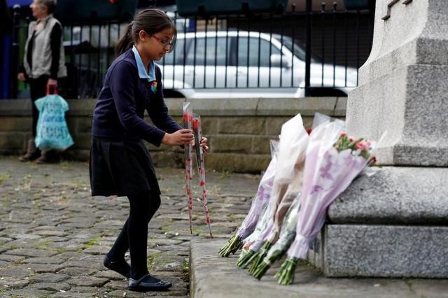 A school girl arrives with flowers to leave in tribute to Jo Cox, near the scene where she was killed in Birstall near Leeds. A school girl arrives with flowers to leave in tribute to Jo Cox, near the scene where she was killed in Birstall near Leeds.