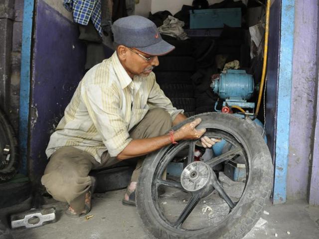 PN Deshmukh, father of AAP MLA Praveen Deshmukh, at his tyre repairing shop.(Mujeeb Faruqui/ HT photo)