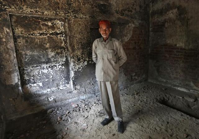 Sayeed Khan Pathan poses inside his house which was burnt and damaged in the Gujarat 2002 riots at the Gulbarg Society. (reuters)