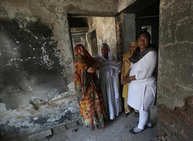 Survivors of the 2002 Gujarat riots weep inside a house that was burnt and damaged in the riots at the Gulbarg Society, (reuters)