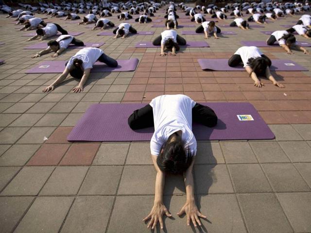 Participants strike a pose during a group yoga session at a park in Beijing. (AP) 
