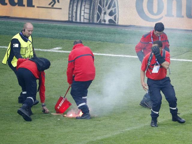 The match is interrupted as stewards tend to flares thrown onto the pitch by fans. (REUTERS)