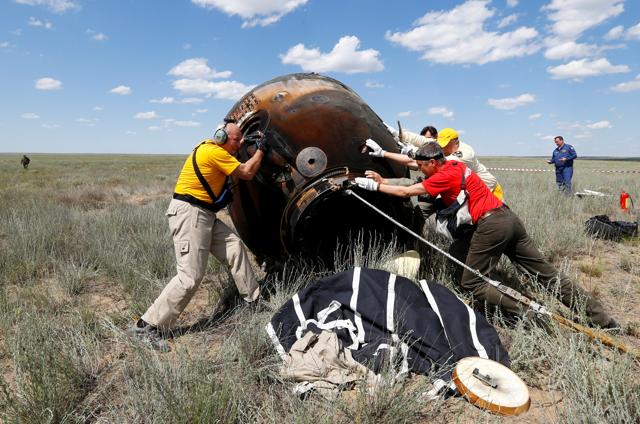 Search and rescue team members roll the Soyuz TMA-19M spacecraft capsule carrying International Space Station crew members.  (REUTERS)