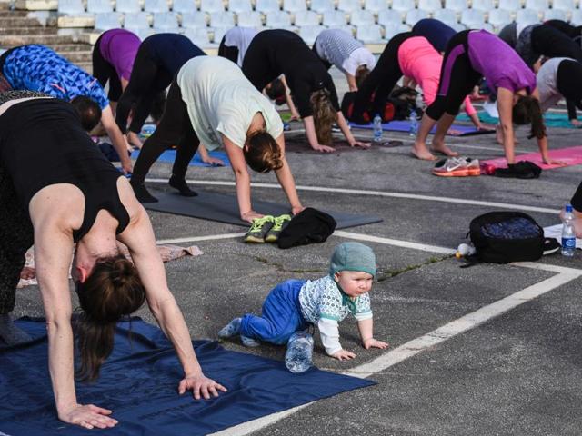 Yoga students and a baby take part in an outdoors yoga class at the Germia National Park in Pristina on June 16, 2016.  (AFP) 