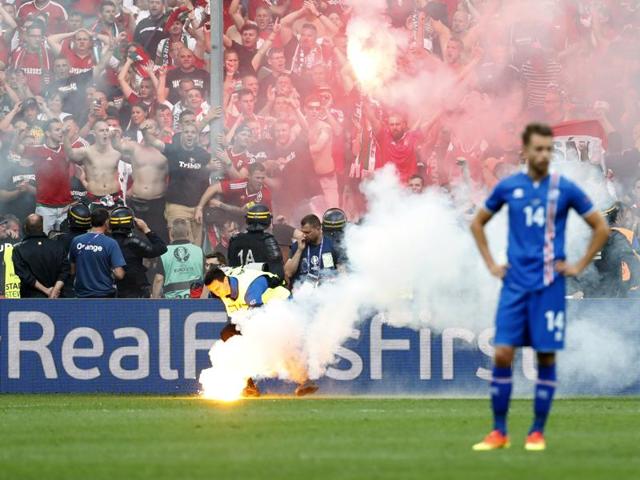 Iceland's Kari Arnason reacts as a steward picks up a flare thrown onto the pitch by Hungary fans after their first goal. (REUTERS)