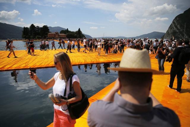 People walk on the monumental installation entitled 'The Floating Piers' created by artist Christo Vladimirov Javacheff on Iseo Lake, in northern Italy, on June 18, 2016. (AFP) People walk on the monumental installation entitled 'The Floating Piers' created by artist Christo Vladimirov Javacheff on Iseo Lake, in northern Italy, on June 18, 2016. (AFP)