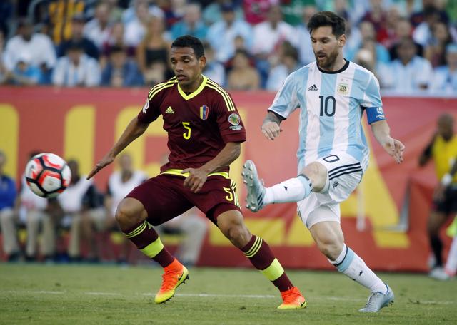 Messi (10) kicks the ball past Venezuela's Arquimedes Figuera (5) during the first half of a Copa America Centenario quarterfinal. (AP)