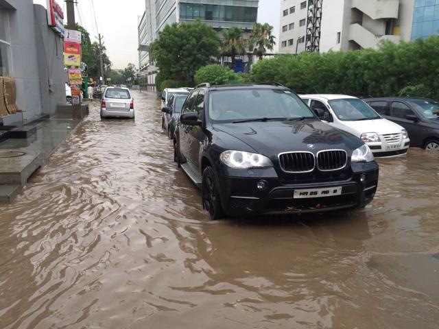 Inside the city, roads and bylanes in several localities were submerged due to choked drains. Areas like DLF Phases, Bristol Chowk, Golf Course road, Sector 15, Sikenderpur, Old railway and new road, Mahavir Chowk, among others, witnessed water logging.(Parveen Kumar/HT Photo)