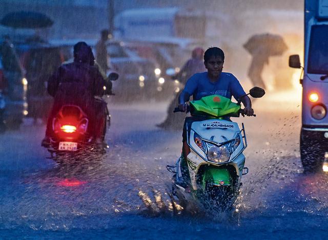 Bikers drive through flooded streets at Sion on Sunday. (HT Photo)