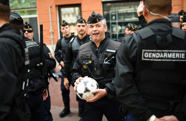 A French gendarm holds the ball of Wales' supporter as his unit patrols through the streets of Toulouse, southern France, on June 20, 2016 before the Euro 2016 football match of Russia vs Wales. (AFP) A French gendarm holds the ball of Wales' supporter as his unit patrols through the streets of Toulouse, southern France, on June 20, 2016 before the Euro 2016 football match of Russia vs Wales. (AFP)