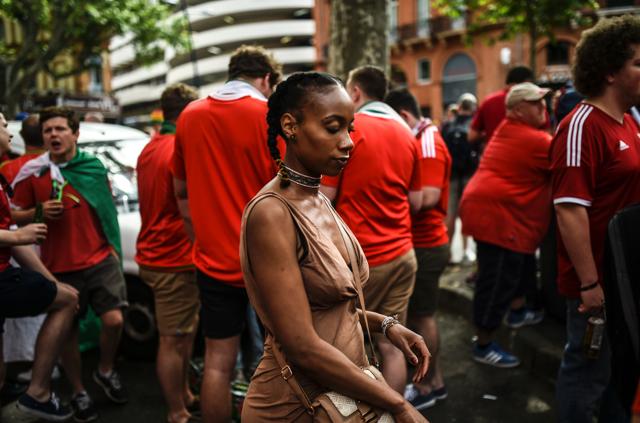 A woman walks past Wales' supporters crowding in the streets of Toulouse, southern France, on June 20, 2016 before the Euro 2016 football match of Russia vs Wales. (AFP) A woman walks past Wales' supporters crowding in the streets of Toulouse, southern France, on June 20, 2016 before the Euro 2016 football match of Russia vs Wales. (AFP)