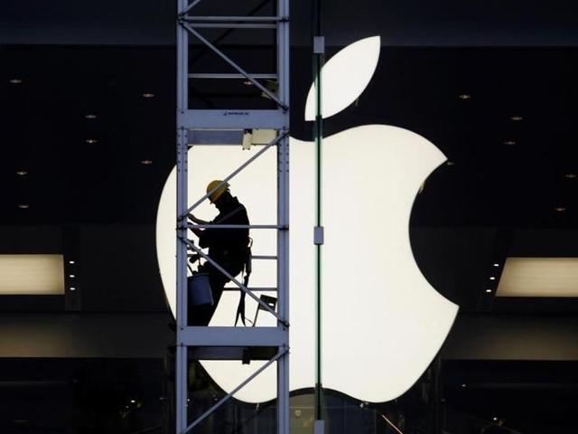 In this file photo, a worker can be seen climbing outside an Apple store in Hong Kong.(Reuters)