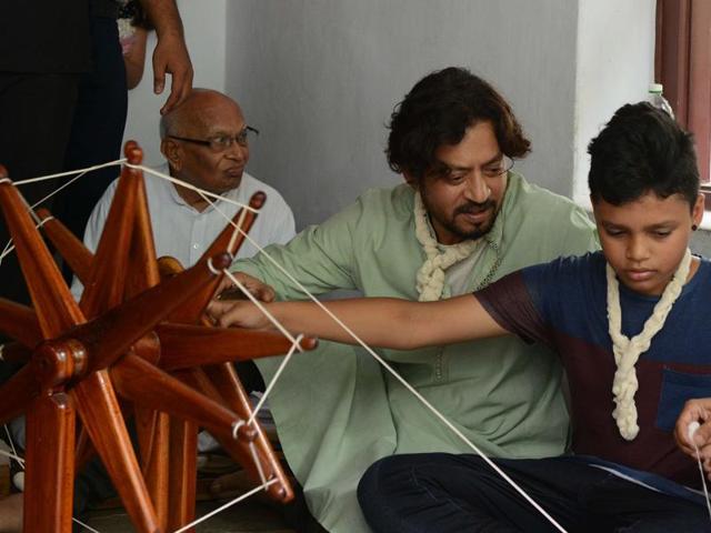 Irrfan Khan watches as his son Aayan learns how to spin thread on a wooden charkha (spinning wheel), helped by a volunteer at the Mahatma Gandhi Ashram in Ahmedabad. (AFP) Irrfan Khan watches as his son Aayan learns how to spin thread on a wooden charkha (spinning wheel), helped by a volunteer at the Mahatma Gandhi Ashram in Ahmedabad. (AFP)