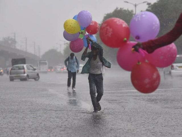 A balloon-seller in Dhaula Kuan runs for shade as rains lash parts of the Capital on Monday. (Ravi Choudhary/ HT Photo) A balloon-seller in Dhaula Kuan runs for shade as rains lash parts of the Capital on Monday. (Ravi Choudhary/ HT Photo)