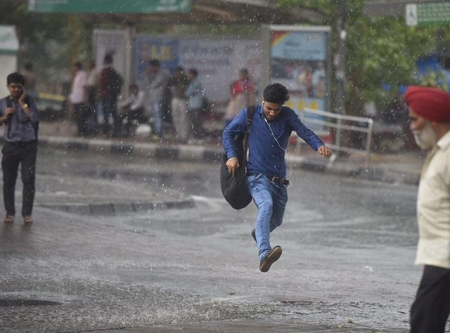 The hot weather suddenly changed and it started pouring, causing panic and rush for many, making them run to save their electronic gadgets from getting wet. (Ravi Choudhary/ HT Photo) The hot weather suddenly changed and it started pouring, causing panic and rush for many, making them run to save their electronic gadgets from getting wet. (Ravi Choudhary/ HT Photo)