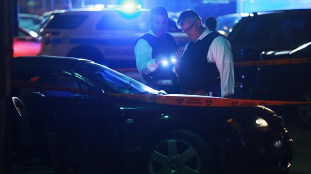 In this Thursday, June 16, 2016 photo, police detectives search for evidence in a car involved in the shooting scene in Chicago. (AP)