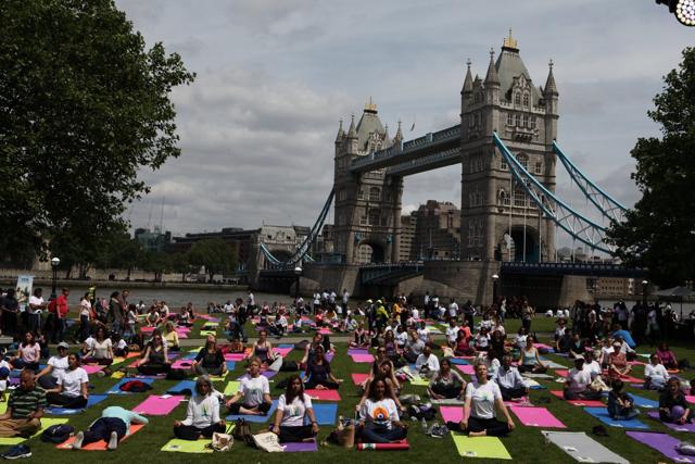 People perform yoga near the Tower Bridge in London. (PIB) People perform yoga near the Tower Bridge in London. (PIB)