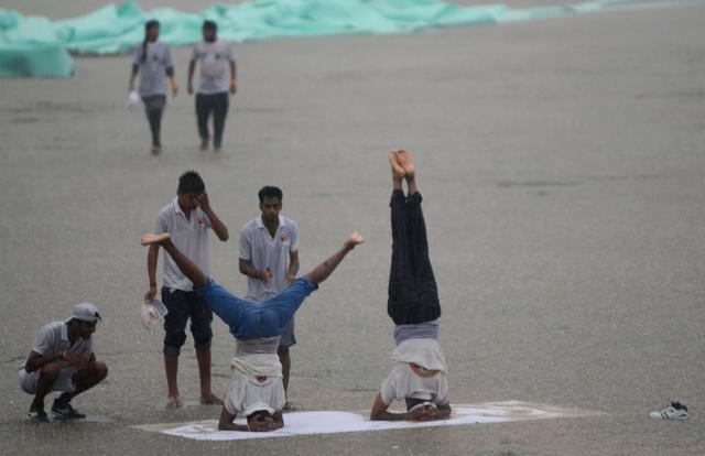Indian yoga enthusiasts take part in a session during heavy rains in Jammu. (AFP) Indian yoga enthusiasts take part in a session during heavy rains in Jammu. (AFP)