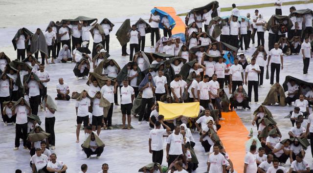 People protect themselves from the rain with yoga mats during a group yoga session celebrating International Yoga Day in Lucknow. (AP) People protect themselves from the rain with yoga mats during a group yoga session celebrating International Yoga Day in Lucknow. (AP)