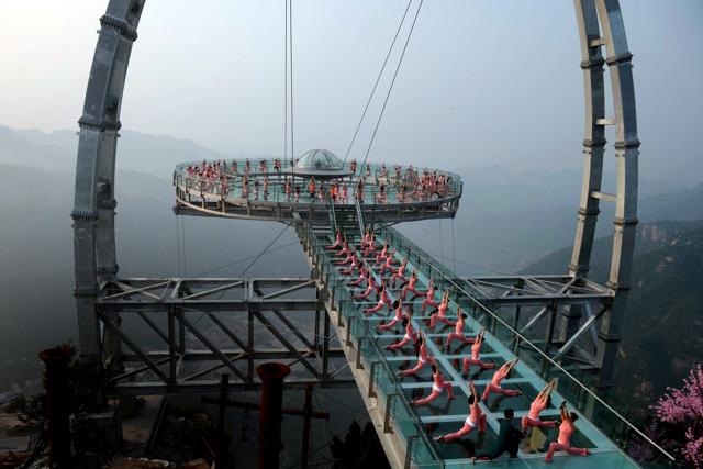 Chinese enthusiasts practising yoga at a glass sigh-tseeing platform in Shilinxia scenic area in Beijing. (AFP) Chinese enthusiasts practising yoga at a glass sigh-tseeing platform in Shilinxia scenic area in Beijing. (AFP)