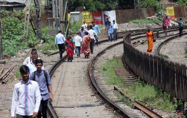 Commuters walk on railway tracks as rains hit services. (Satyabrata Tripathy/ HT Photo) Commuters walk on railway tracks as rains hit services. (Satyabrata Tripathy/ HT Photo)