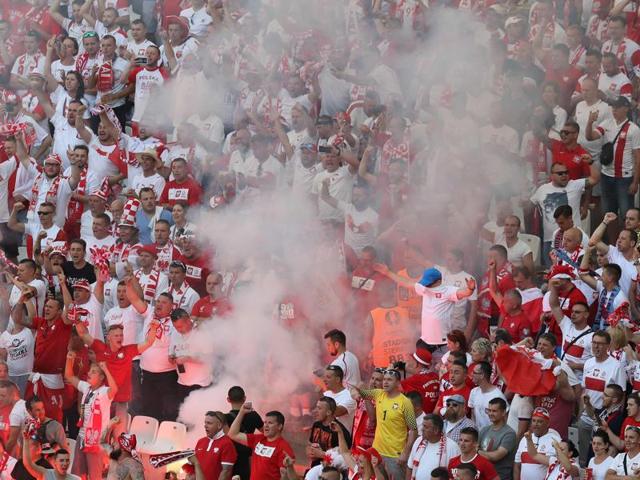 Poland supporters light a flare during the match. (AFP)