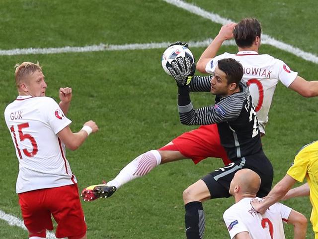 Poland's goalkeeper Lukasz Fabianski (C) grabs the ball. (AFP)