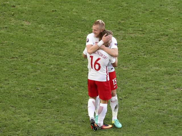 Poland's Kamil Glik and teammate Jakub Blaszczykowski (16) congratulate each other after winning their Euro 2016 Group C match against Ukraine at the Velodrome stadium in Marseille, France, on June 21, 2016. Poland won 1-0. (AP)
