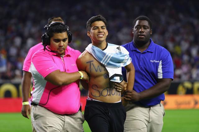 A fan is escorted by security after running onto the field prior to the start of the second half of a 2016 Copa America Centenario semifinal match. (AFP Photo)