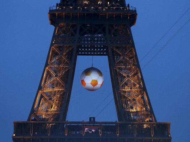 A giant football hangs on the Eiffel Tower during the Euro 2016 Group A match between France and Romania. (AP photo) 