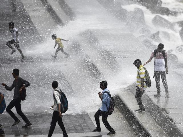 Children enjoy the high tide at Marine Drive on Wednesday.(Arijit Sen/ HT)
