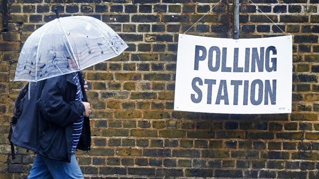 A man shelters from the rain as he arrives at a polling station in London on June 23, 2016. (AFP) A man shelters from the rain as he arrives at a polling station in London on June 23, 2016. (AFP)