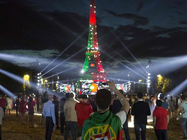 People watch on a giant screen a Euro 2016 football match at the fan zone in front of the Eiffel Tower in Paris. (AFP Photo) 