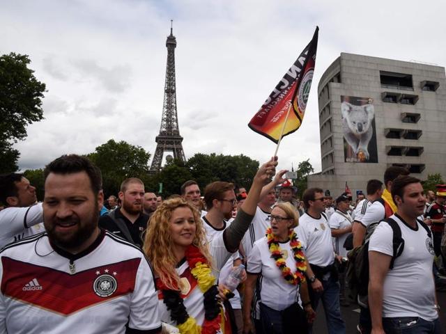 German fans wave national flags and cheer for their team during the fan walk between the Eiffel tower and Parc des Princes, in Paris. (AFP Photo) 