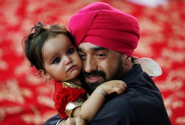 An Afghan Sikh holds his child inside a Gurudwara, or a Sikh temple, during a religious ceremony in Kabul, Afghanistan. (Reuters) An Afghan Sikh holds his child inside a Gurudwara, or a Sikh temple, during a religious ceremony in Kabul, Afghanistan. (Reuters)