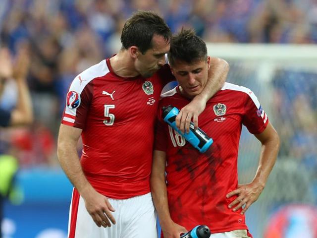 Austria's Christian Fuchs, left, tries to console his teammate, Alessandro Schoepf, at the end of the match. (AP)