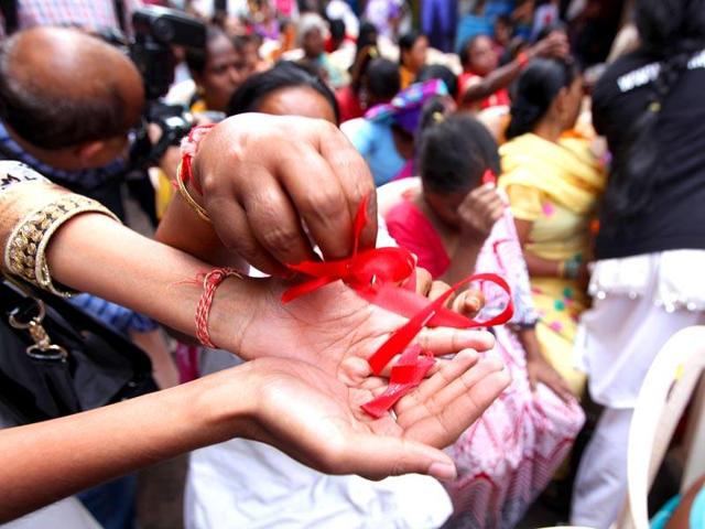 Sex workers distribute red ribbons at a rally on World Aids Day in Mumbai.(HT Photo)