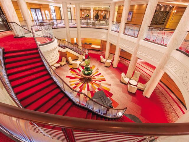 The sweeping staircase of the atrium at the refurbished luxury transatlantic liner is newly carpeted and new artwork adorns the walls.  (AFP) 