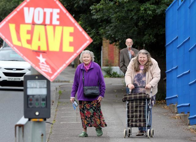 People walk past a "Vote Leave" sign as they arrive to cast their ballots at a polling station in Belfast, Northern Ireland on Thursday. (AFP) People walk past a "Vote Leave" sign as they arrive to cast their ballots at a polling station in Belfast, Northern Ireland on Thursday. (AFP)